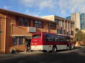 and image of a red bus stopped at the side of a street