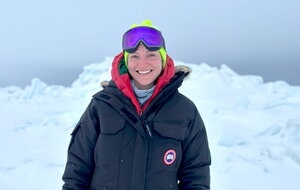A person standing on ice in winter gear.