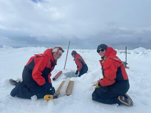 Two researchers taking ice core samples.
