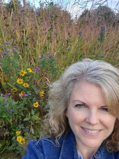 Anita Shore standing in a restored prairie.