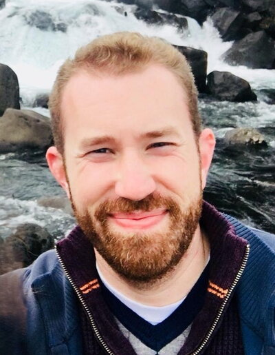 Jordan McAlister in front of a waterfall.