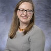 A woman with glasses posing for a headshot.