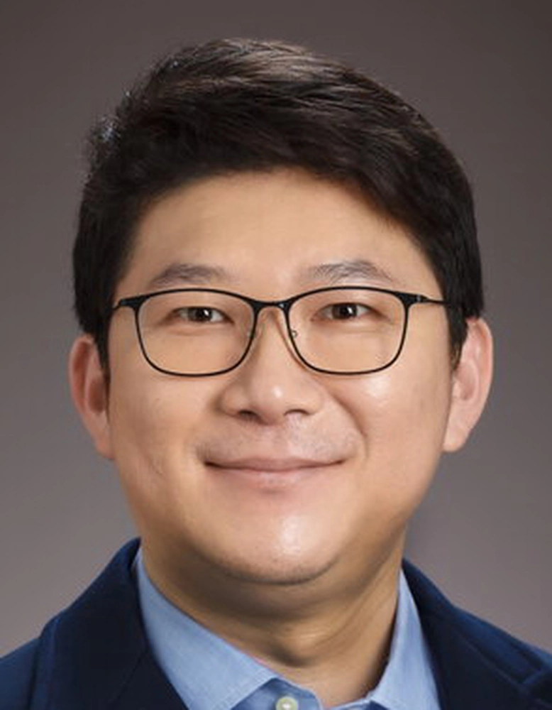 A man with glasses smiling for the camera.