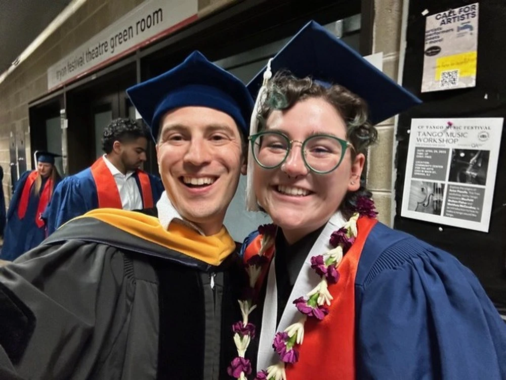 Two people in graduation caps and gowns.