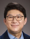A man with glasses smiling for the camera.