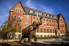 A statue of a mammoth in front of a brick building.